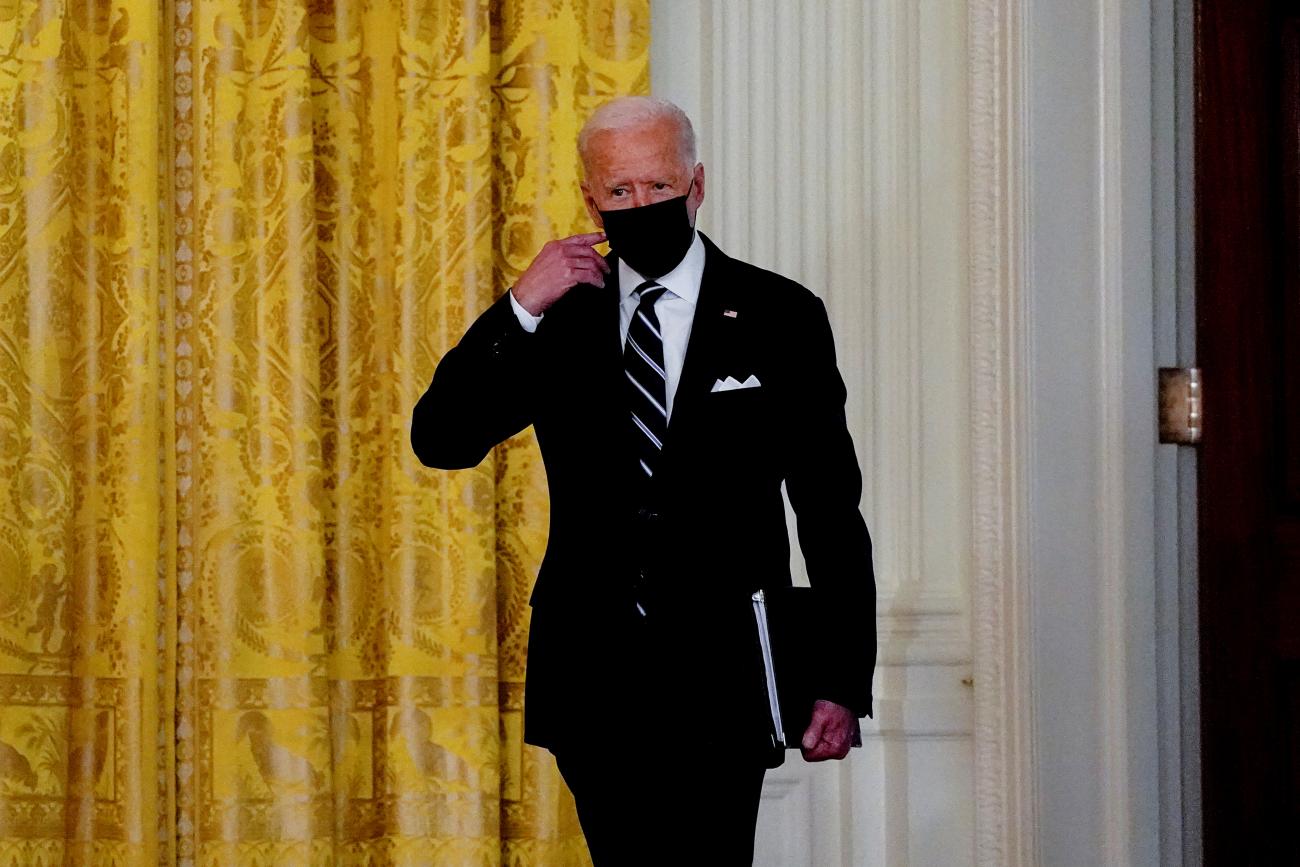 U.S. President Joe Biden removes his face mask as he arrives to deliver remarks on the COVID response and vaccination program at the White House in Washington, DC, on August 18, 2021. 