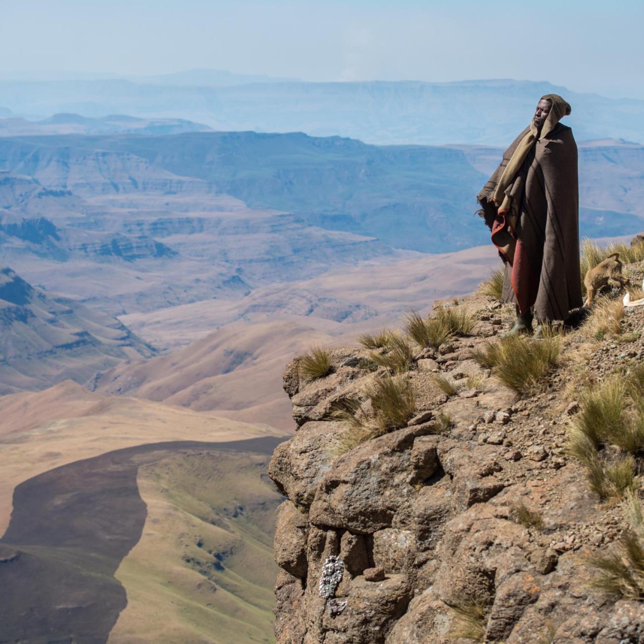 Basotho shepherd and dog looking out from a mountain ledge, in Thaba Tseka, Lesotho. Photo courtesy of Edwin Remsberg