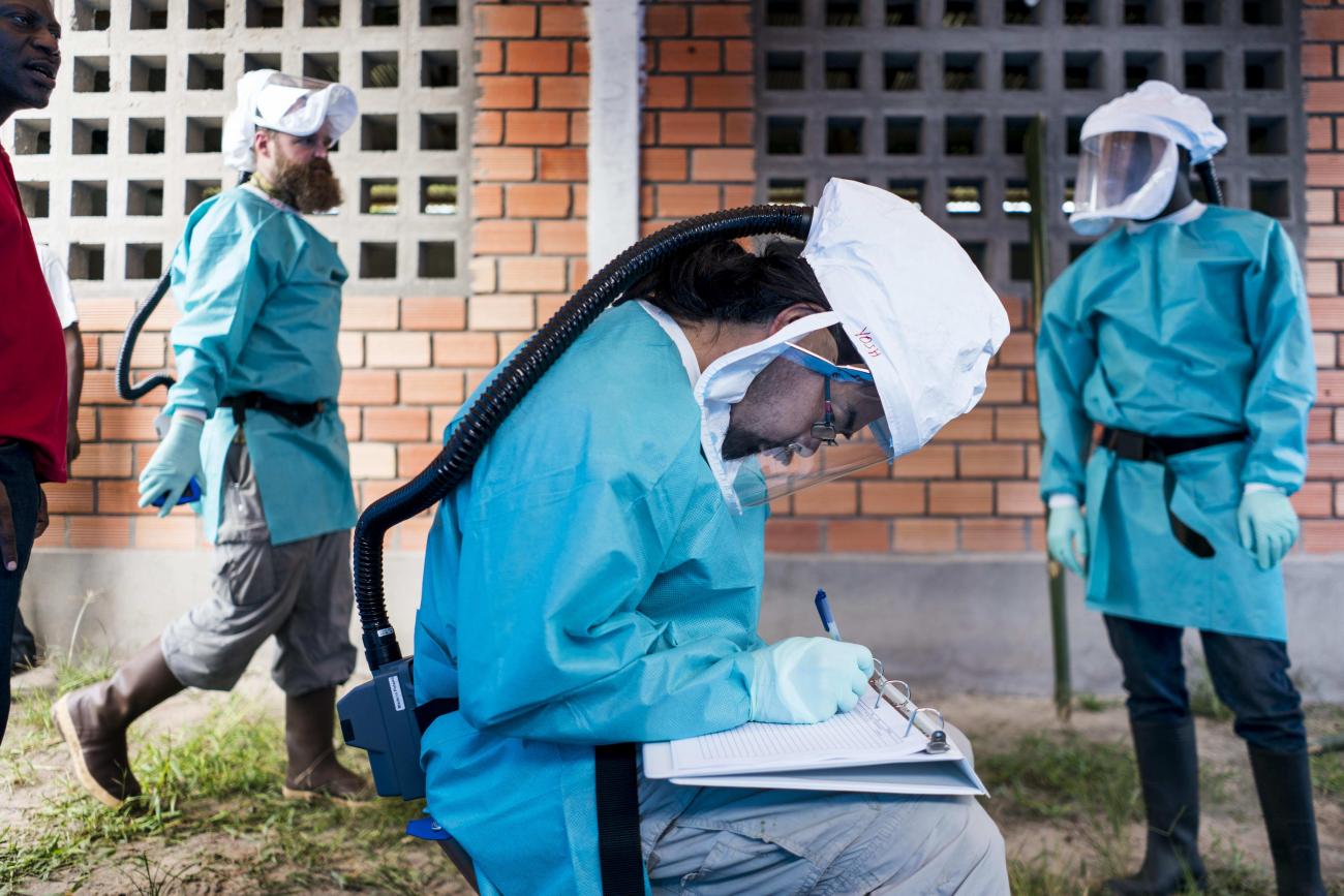 CDC biologists a and Congolese scientist wear blue surgical gowns and respirators, as they examine animals caught in the jungle who may carry the MonkeyPox virus, in Manfuette, Republic of Congo on August 29, 2017