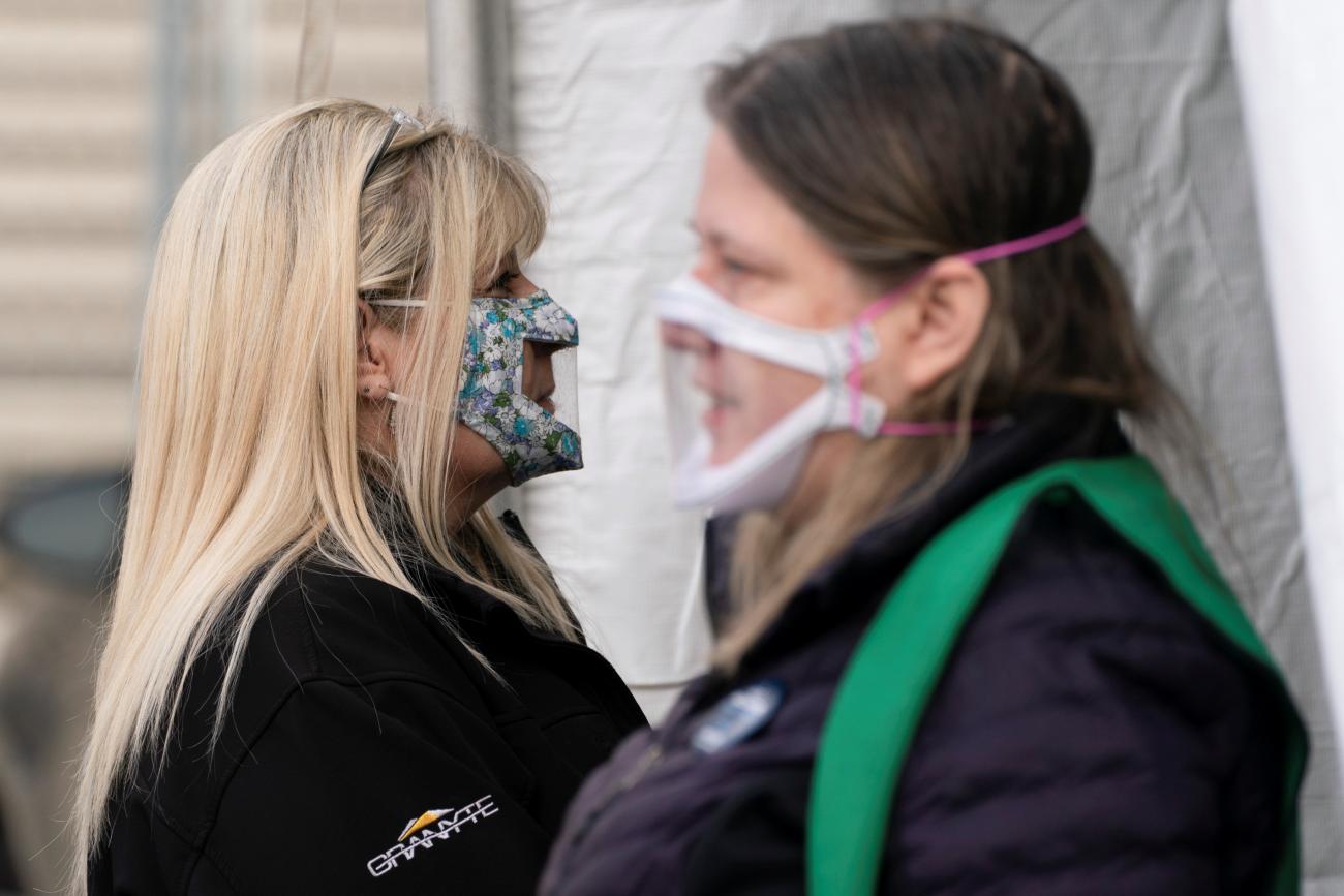 Interpreters wait at the entrance of a mobile coronavirus disease (COVID-19) vaccination clinic for members of the deaf and blind community, organized by the Swedish Medical Center in Seattle, Washington, U.S., March 19, 2021.