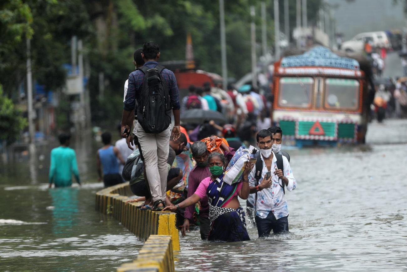 People wade through a waterlogged road after heavy rainfall in Mumbai, India, September 23, 2020. 