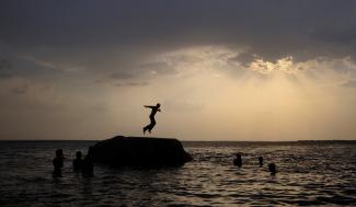 A boy prepares to jump off a rock into the waters of the Osman Sagar Lake near the southern Indian city of Hyderabad May 29, 2011. 