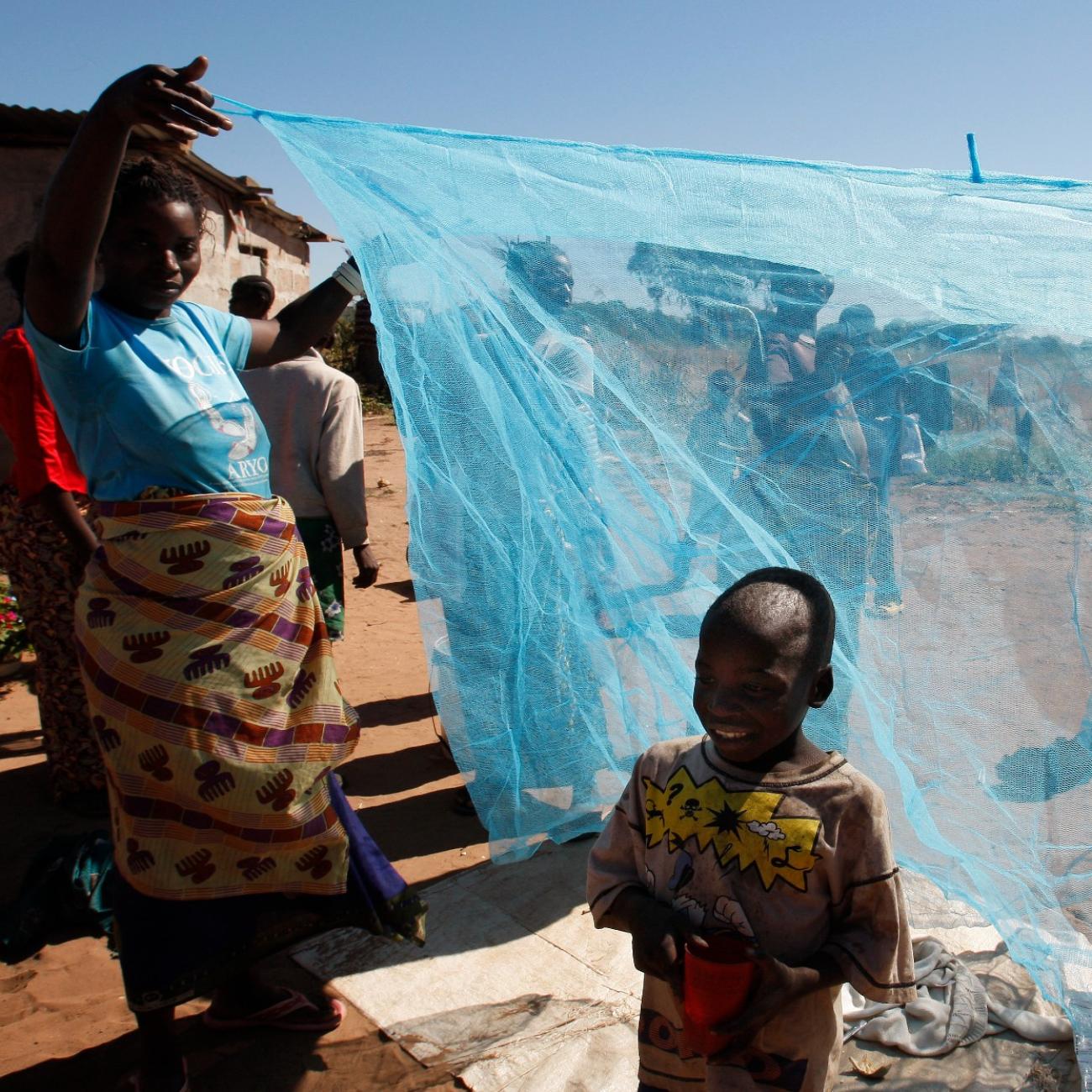 Zambian villagers display a mosquito net in Matongo village, in Zambia, on April 23, 2008.