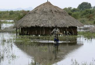 A boy walks away from a flooded hut in Abuket village in Soroti district.