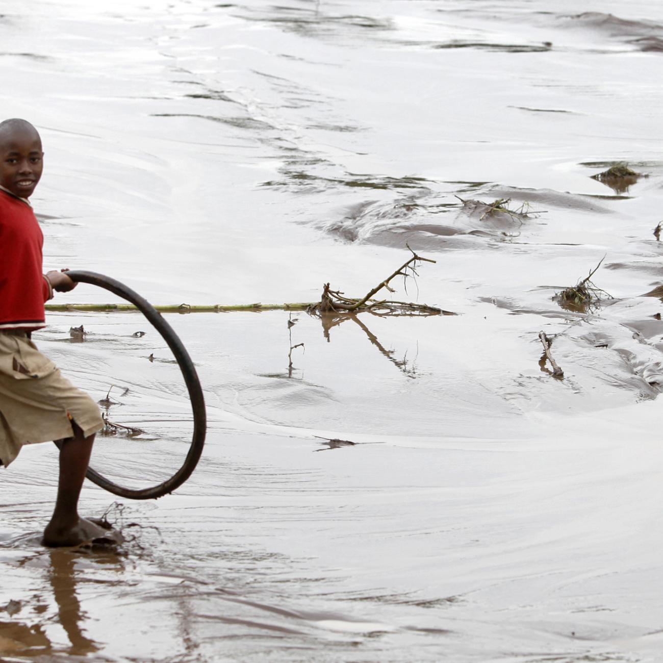 A boy wades through floodwaters after heavy rains in Bududa village.