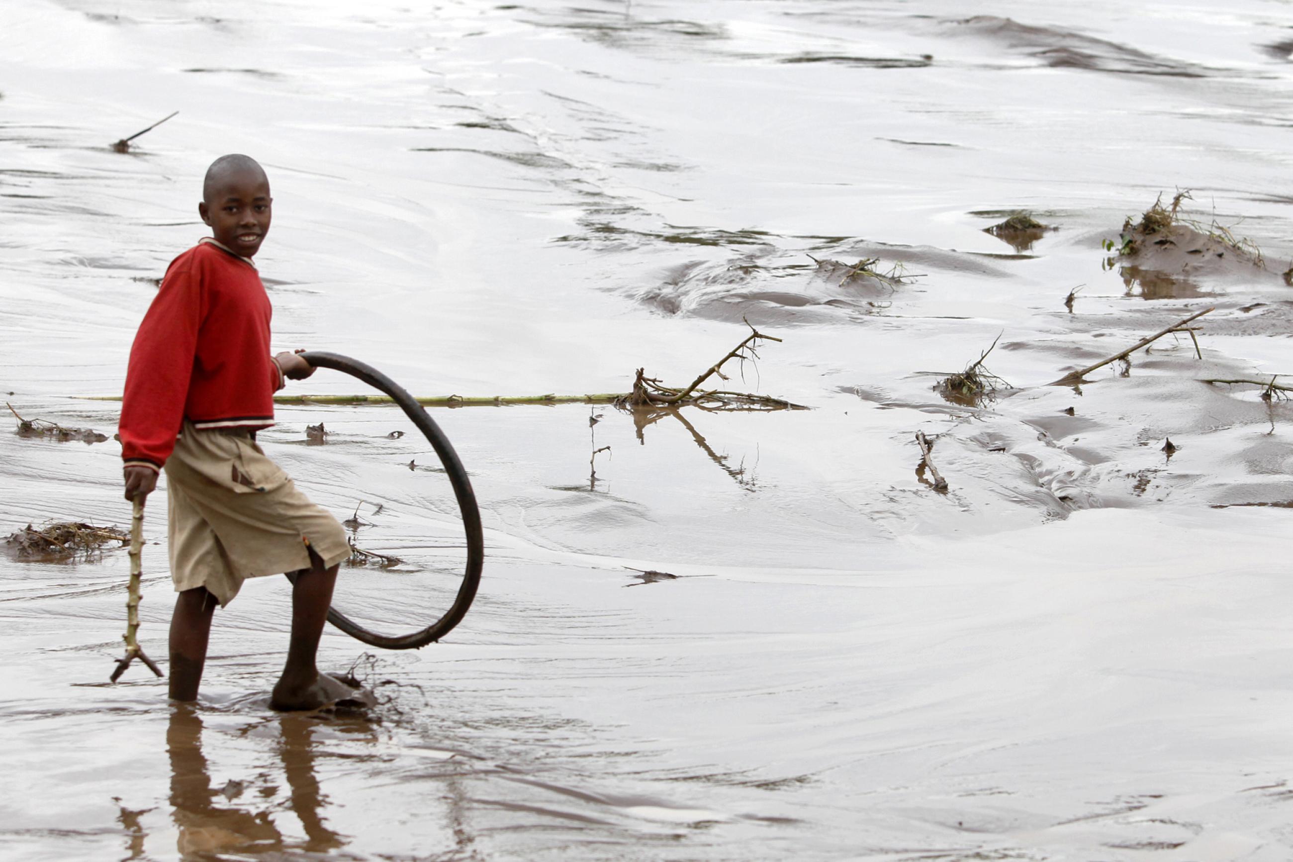 A boy wades through floodwaters after heavy rains in Bududa village.