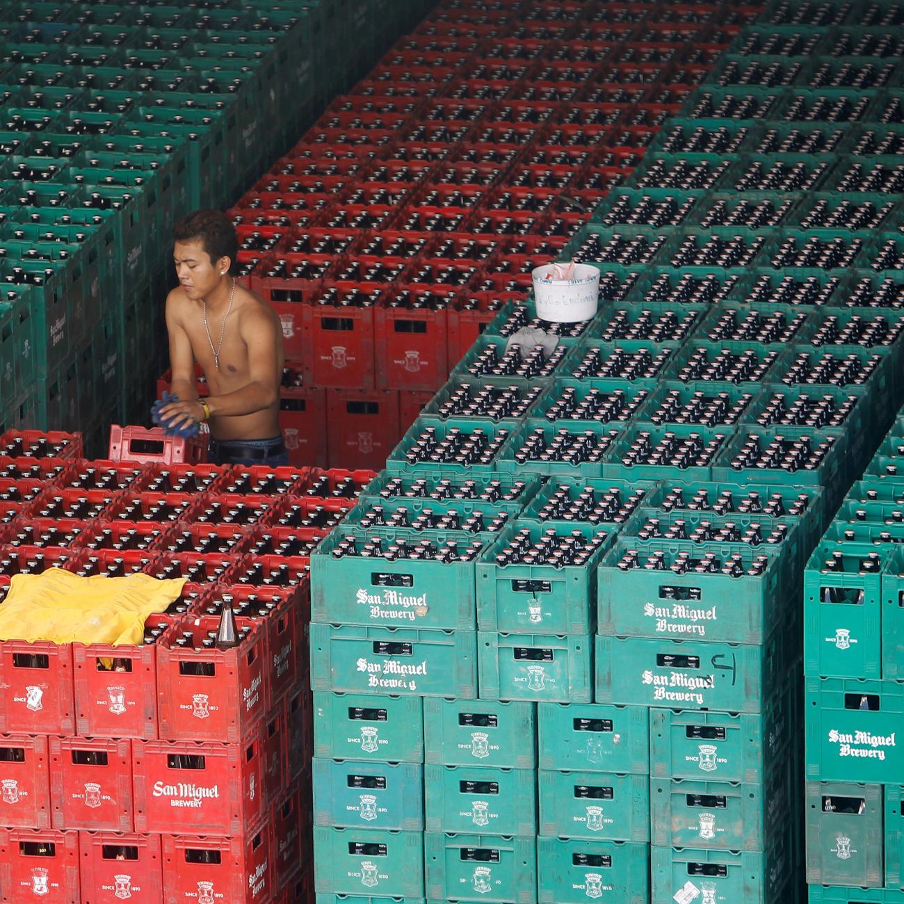 A worker arranges crates of beer before loading them onto a truck inside a San Miguel beer warehouse in Manila, November 14, 2012.
