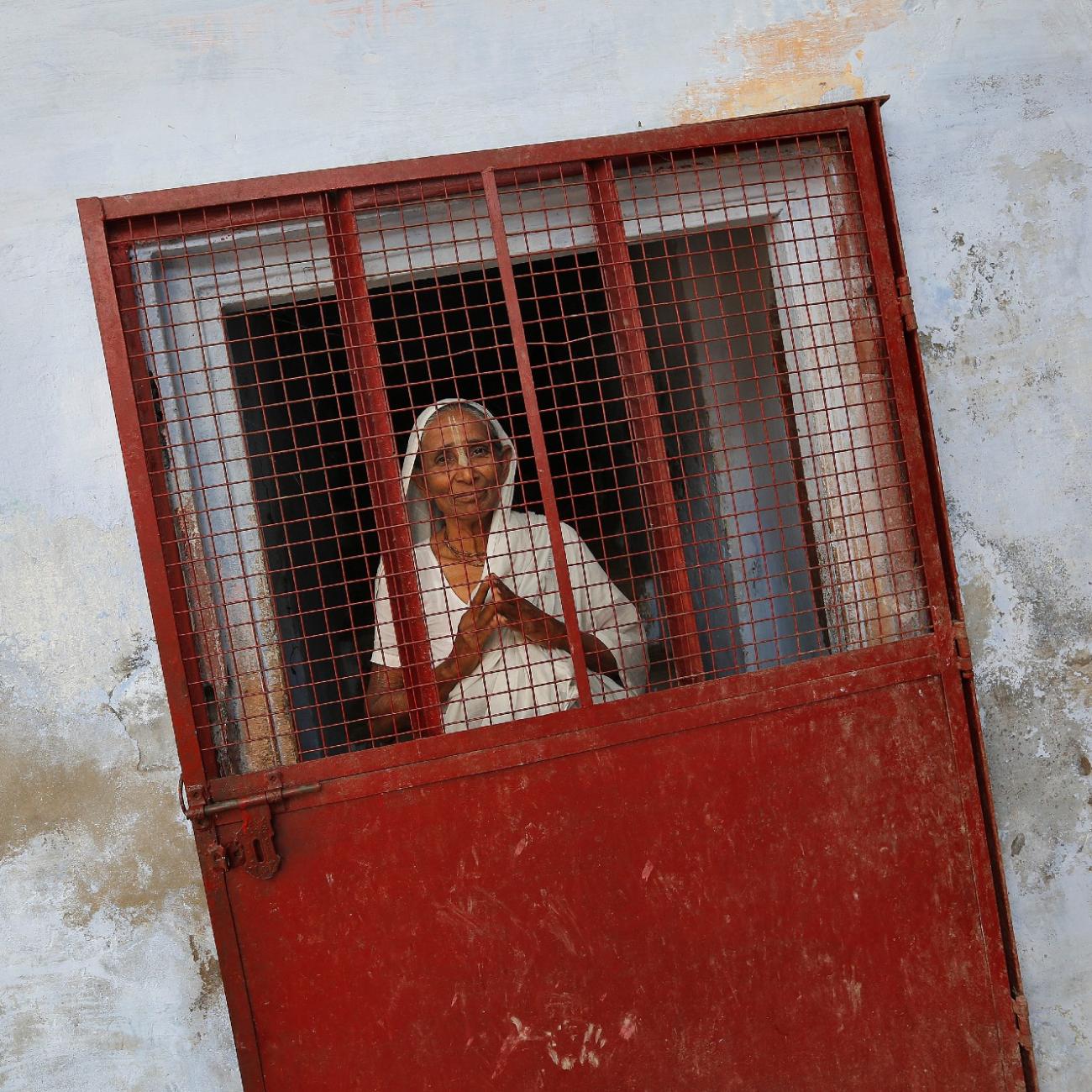 A widow poses at the entrance of a staircase at the Meera Sahavagini ashram in the pilgrimage town of Vrindavan, in Uttar Pradesh, India, on March 6, 2013.
