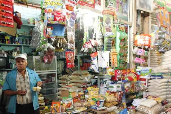 A man sells groceries at his store in a market.