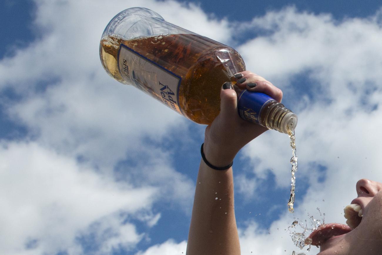 A woman pours alcohol from the bottle into her mouth at the Far Hills Race Day at Moorland Farms in Far Hills, New Jersey, on October 17, 2015. 