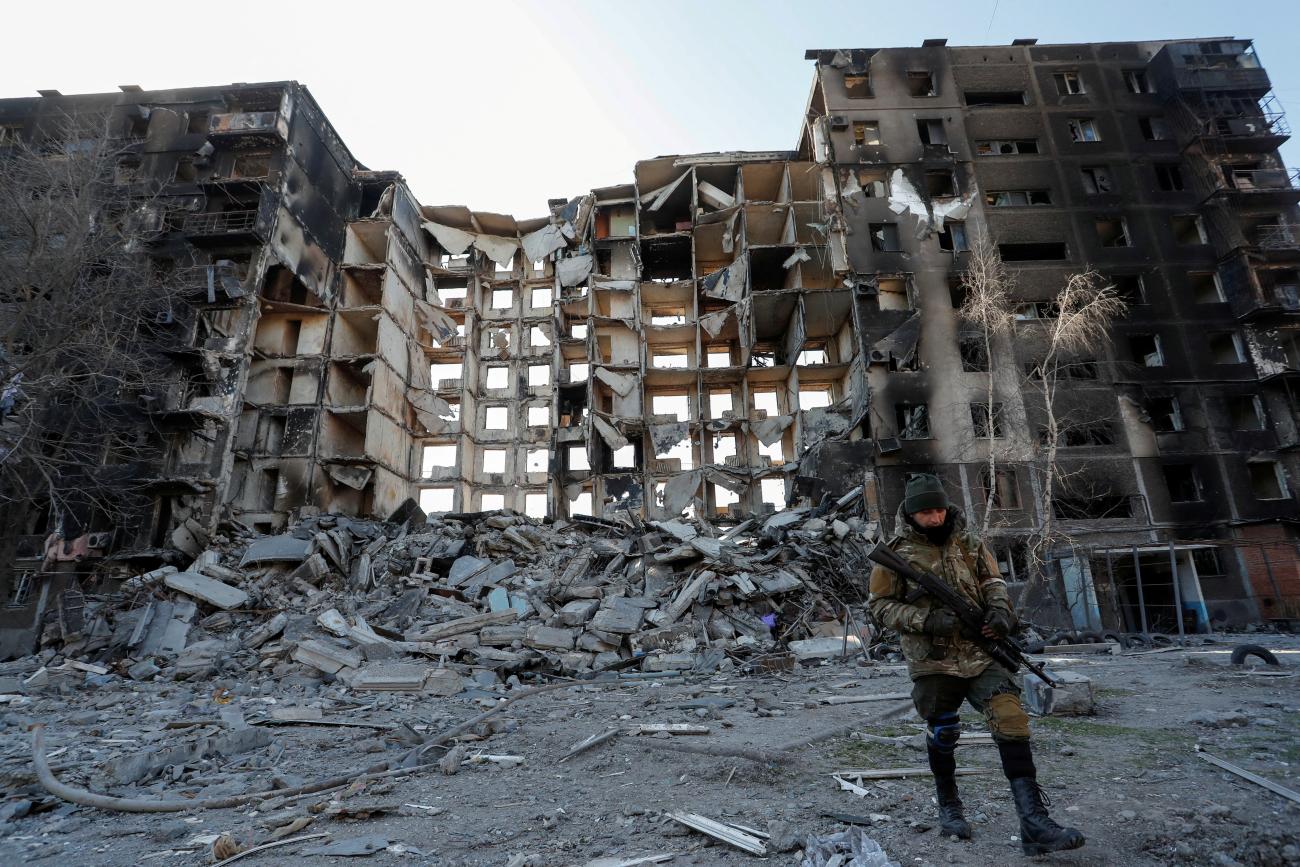 A service member of pro-Russian troops walks near an apartment building destroyed in the course of Ukraine-Russia conflict.