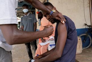 Sulayman Jalloh, a heath worker, vaccinates a driver from the Bundung garage during a mobile vaccination campaign against COVID-19 in Banjul, Gambia, on May 11, 2022.