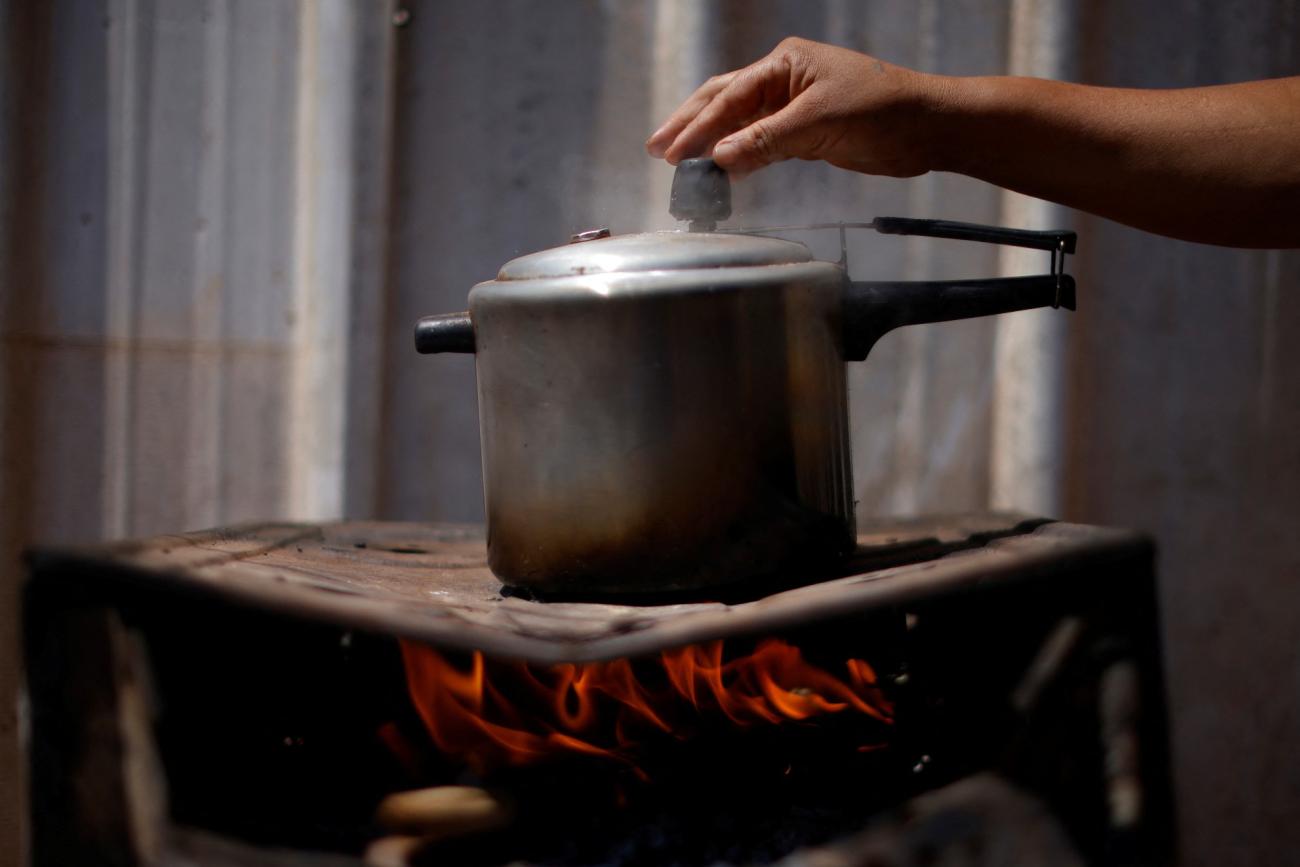 Luciana Messias dos Santos, 29, cooks using firewood outside her home in the Estrutural favela in Brasilia, Brazil, August 31, 2022. 