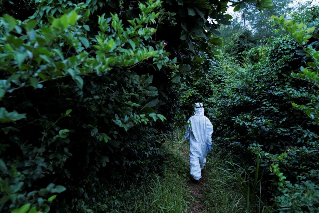 A member of a research team investigating emerging zoonotic diseases walks towards a bat breeding shed at the Accra Zoo in Accra, Ghana, on August 19, 2022.