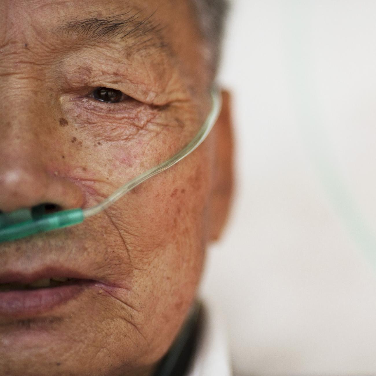 Hu Hushen, a 78 year old former miner, breathes using a nasal cannula for oxygen supply outside his room at Yangjia Hospital in Wuyi County, Zhejiang Province, China October 19, 2015. 