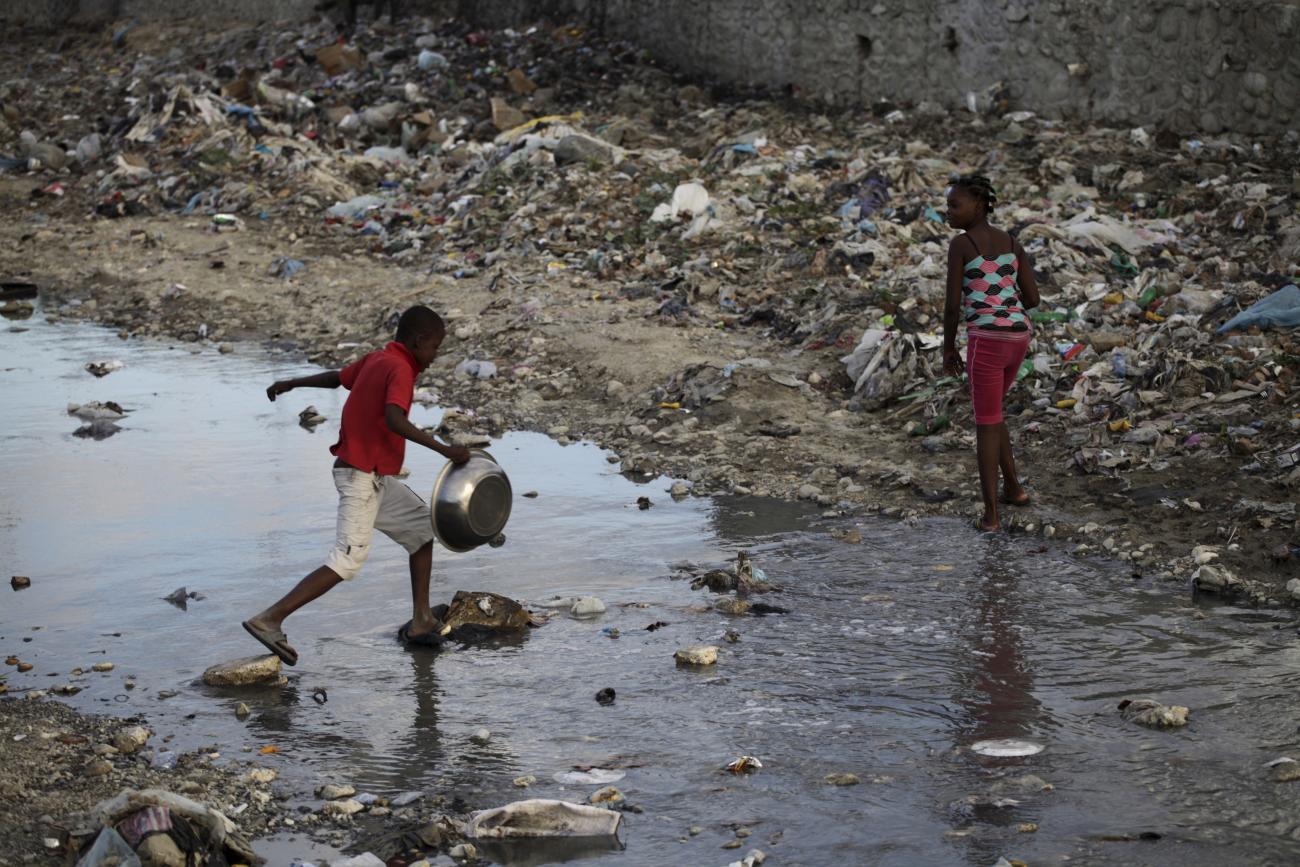 Children cross a polluted canal 