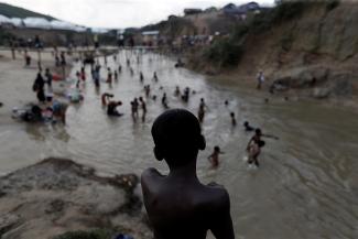 Rohingya refugees swim in a river running through a camp in Cox's Bazar