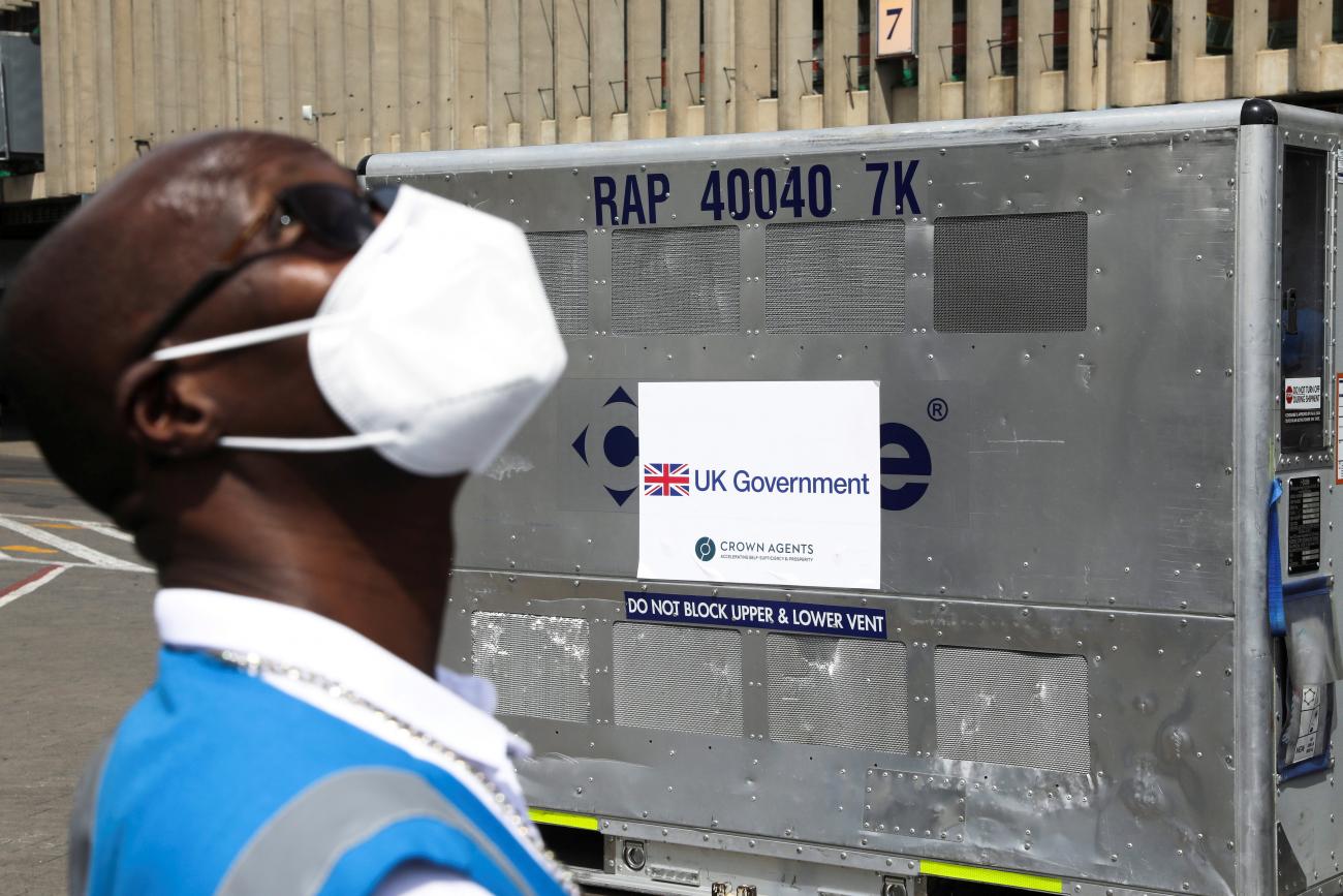 A health official stands next to a container holding a shipment of more than 400,000 doses of the AstraZeneca/Oxford COVID-19 vaccine, donated by the the British government, in Nairobi, Kenya.