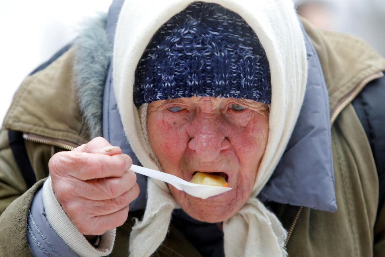 An elderly woman has a meal during a charity event to distribute food among lower-income citizens in a cathedral compound in Stavropol, Russia December 13, 2019