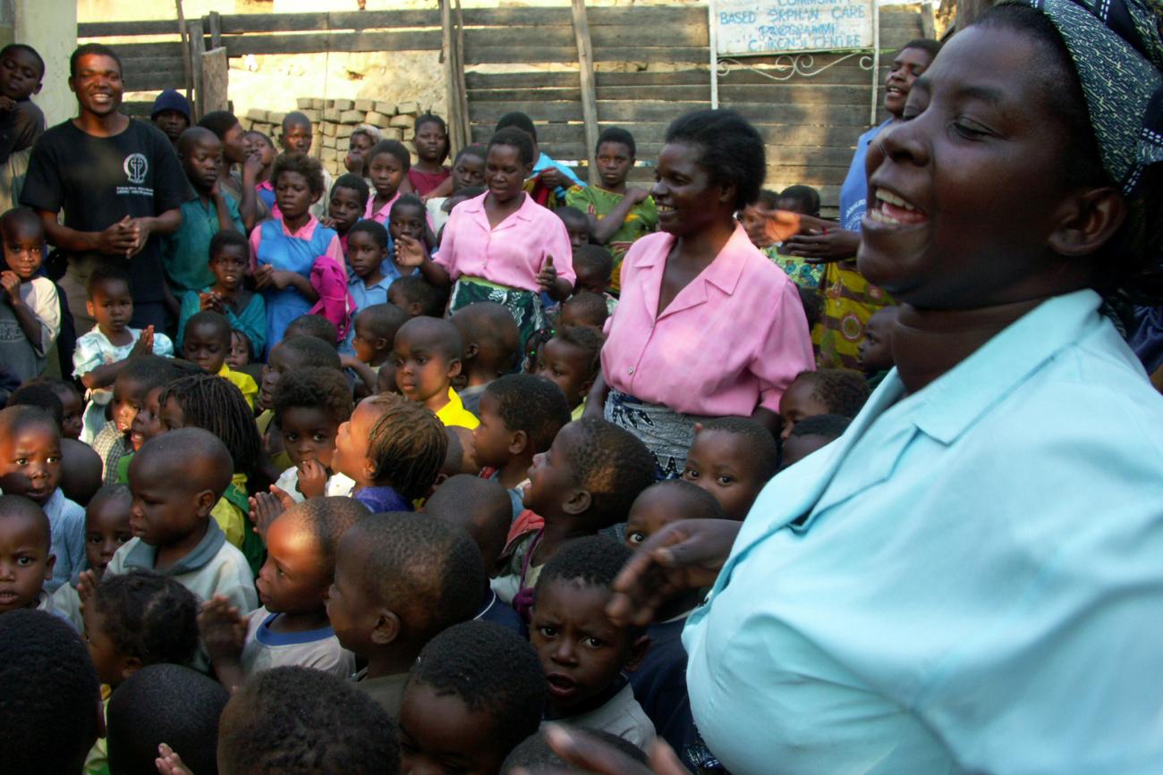 Community worker Grace Angoni sings with children at the Chifundo orphan care center in Blantyre.
