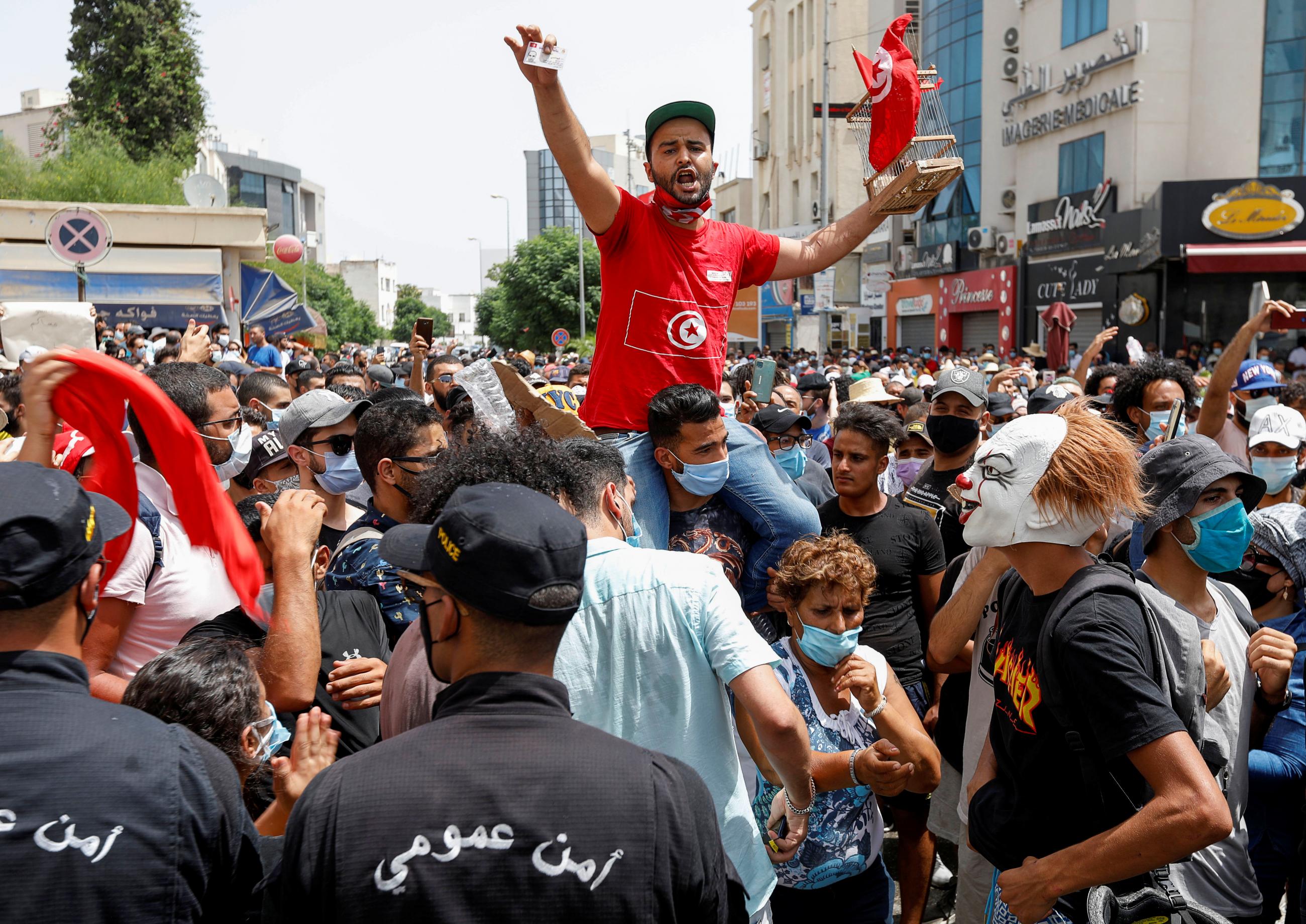 Demonstrators gather in front of police officers standing guard during an anti-government protest in Tunis, Tunisia on July 25, 2021.