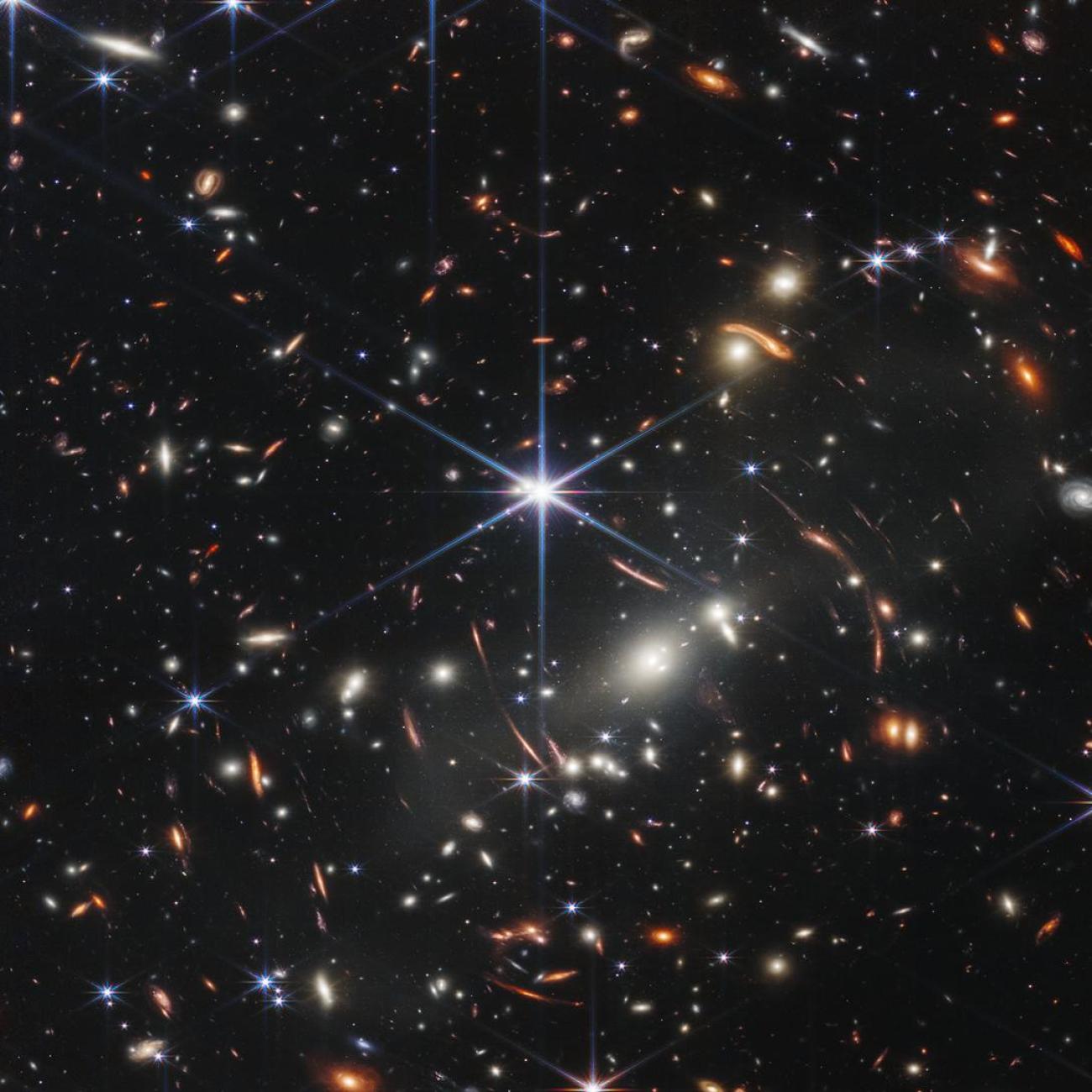 Thousands of galaxies flood this near-infrared image of galaxy cluster SMACS 0723. High-res imaging from NASA’s James Webb Space Telescope and gravitational lensing made the image possible. 