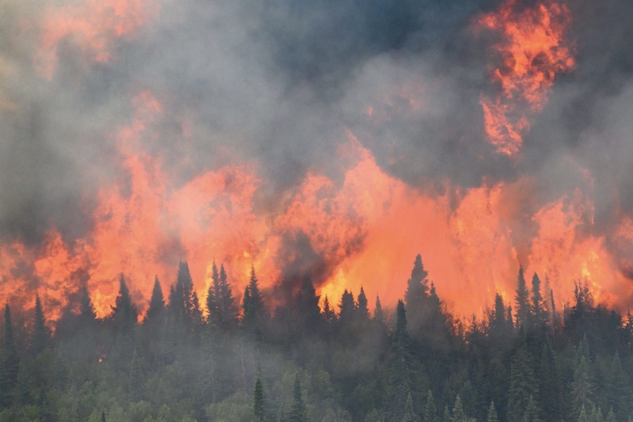 Flames reach upwards along the edge of a wildfire as seen from a Canadian Forces helicopter surveying the area near Mistissini, Quebec, Canada June 12, 2023. 